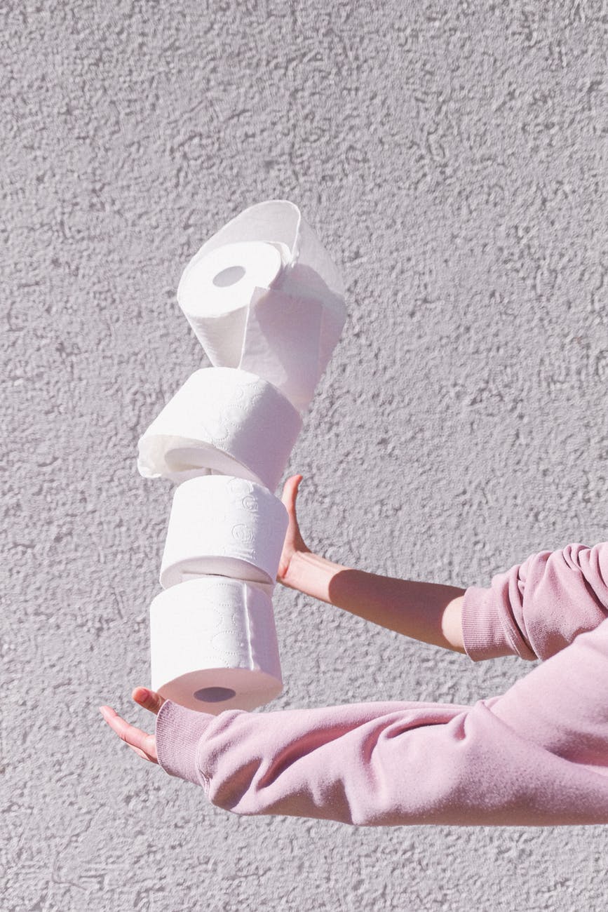 person in pink long sleeve jumper holding white tissue papers